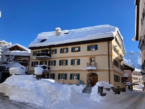 A multi-story building with balconies, snow-covered surroundings, and a clear blue sky. - Ferienwohnungen Chasa Werro, (Sent) by Interhome (Sent)
