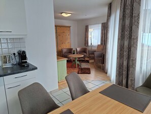 Ein modernes Wohnzimmer mit Küche, Essbereich und Sitzgelegenheit.