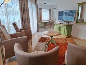 Un salon avec un téléviseur, une table à manger et des chaises.