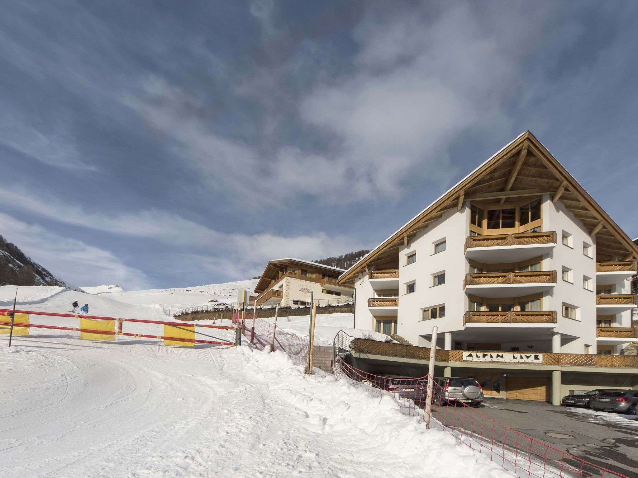 Un hôtel à plusieurs étages avec une piste de ski en arrière-plan.