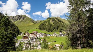 A mountain village with chalet-style buildings, a winding road, and lush greenery. - Atlantis Apartments by MEIN SAMNAUN – MOUNTAIN HOMES, (Samnaun-Ravaisch) by Interhome (Samnaun-Ravaisch)