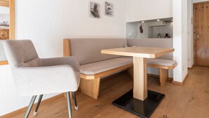 A modern room with a wooden bench, a table, and a chair.