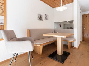 A modern room with a wooden bench, a table, and a chair.