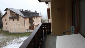 Ein Balkon mit Blick auf ein Gebäude mit mehreren Fenstern und Balkonen.
