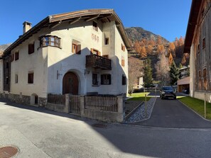 A traditional building with a stone facade, a wooden balcony, and a mountain backdrop. - Chasa Städler, (Zernez) by Interhome (Zernez)