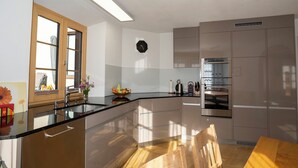 Una cucina moderna con una grande isola, elettrodomestici in acciaio inossidabile e un tavolo da pranzo in legno.