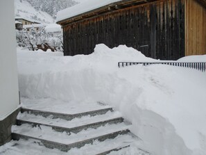 Escada coberta de neve que leva a um edifício de madeira.