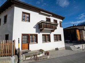 Ein zweistöckiges Gebäude mit Balkon, Holzhörnern und einer Kopfsteinpflasterstraße.