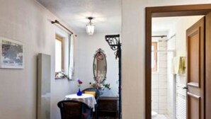 A hallway with a dining area, a mirror, and a door leading to another room. - Chasa Quirin, (Zernez) by Interhome (Zernez)