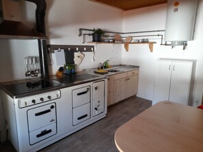 A compact kitchen with a stove, sink, and cabinets. - Ferienwohnungen Paclerahof, (Sta. Maria - Santa Maria Val Müstair) by Interhome (Sta. Maria GR)