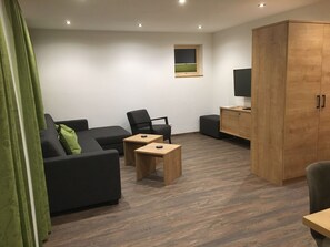 A modern living room with a sofa, two small tables, a cabinet, and a television. - Suot Crapalb, (Samnaun-Laret) by Interhome (Samnaun)