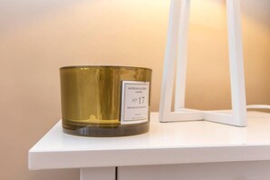Eine Kerze auf einem weißen Regal mit dem Aufdruck 'MORGAN & GRACE No 17 ORCHID & CHAMPION CANDLE'.
