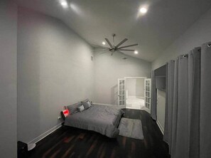 A bedroom with a bed, a ceiling fan, and a door leading to an adjacent room. - 1932 Relax in East Lake - Modern Retreat - Vacation Home in DeKalb County (Decatur)