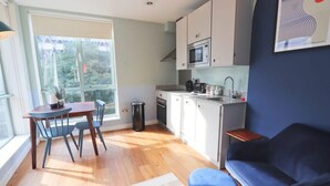 A compact kitchen with a dining area, a sofa, and a window with a view. - Prince Street Studio 9 - Hopewell (Bristol)