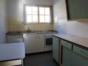 A compact kitchen with a sink, stove, oven, and cabinets. - Ferienhaus Chasa Allegra, (Scuol) by Interhome (Scuol)