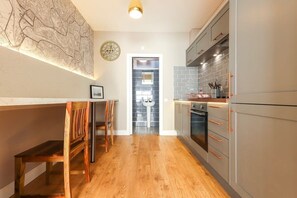 Une cuisine moderne avec un plancher en bois, un coin repas avec un banc et une carte accrochée au mur.