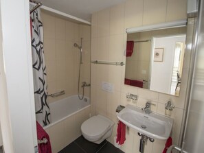 Une salle de bain avec une baignoire, des toilettes et un lavabo.