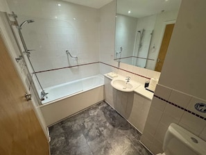 Ein Badezimmer mit Badewanne, Waschbecken, Toilette und Duschbereich.