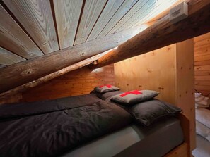 A bunk bed with a wooden ceiling and slanted walls. - Bergblick-Craistas, (Sta. Maria - Santa Maria Val Müstair) by Interhome (Sta. Maria GR)