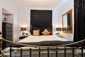 A bedroom with a bed, bedside tables, a dresser, a large mirror, and a tapestry on the wall. - 2 Bedroom flat near Whiteladies road (Bristol)