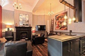 A modern living room with a fireplace, a television, and a dining area with a bar. - 2 Bedroom flat near Whiteladies road (Bristol)