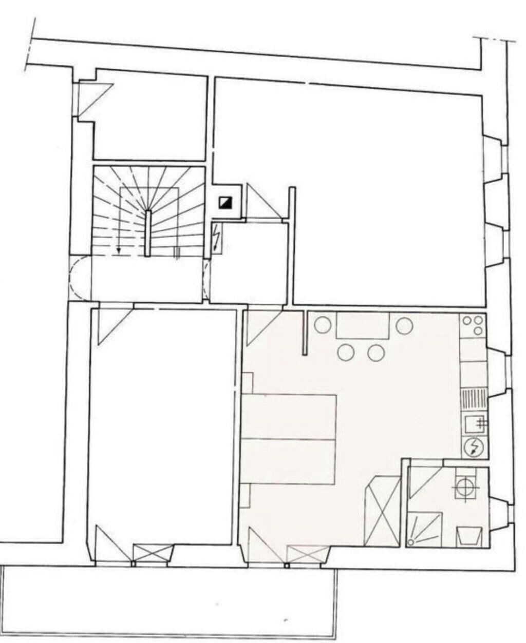 Ein Grundriss mit einem zentralen Wohnbereich, einer Küche, einem Essbereich und einer Treppe.