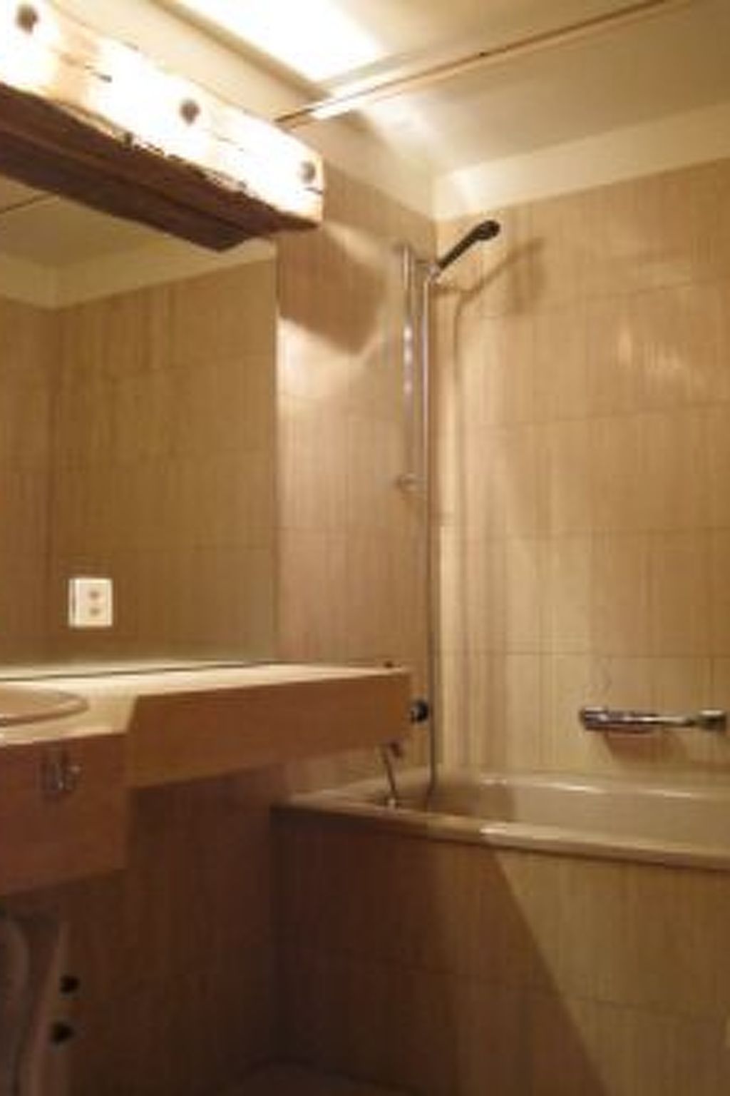 Un bagno con doccia, lavandino e specchio.