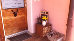 Une porte en bois ornée d’une tête de cerf et sur laquelle est affiché un panneau d’accueil dans plusieurs langues.