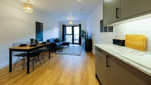 Una cucina moderna con un piano di lavoro in marmo, un tavolo da pranzo in legno e sedie nere.