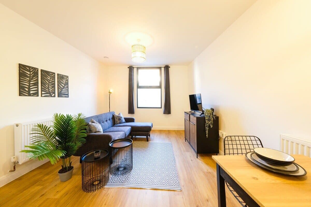 Un salon moderne avec un canapé, une table à manger, une plante en pot et un radiateur.