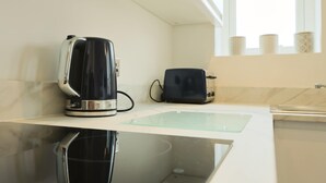 A modern kitchen with a kettle, toaster, and a glass sink. - Winchester two bedroom property in Brislington (Bristol)