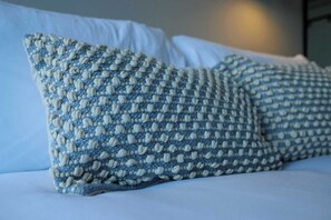 A bed with two pillows featuring a textured pattern.