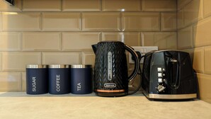 A kitchen counter with a coffee maker, kettles, and a toaster.