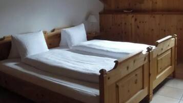 Une chambre à coucher avec un lit en bois, une literie blanche et un plafond en pente.