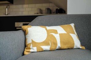 A grey sofa with a patterned cushion. - The Willow - Studio 14 (Patchway)