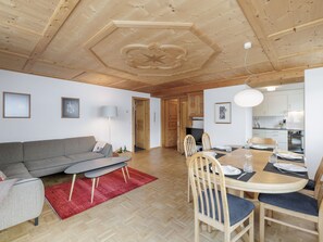 A modern living room with a sofa, dining table, and chairs. - Plazzöl 111B, (Ftan) by Interhome (Ftan)