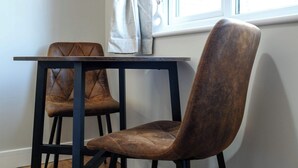 Eine Sitzecke mit zwei braunen Sesseln und einem kleinen Tisch mit dunklem Gestell.