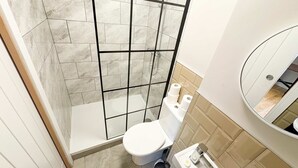 A bathroom with a shower, toilet, and sink.