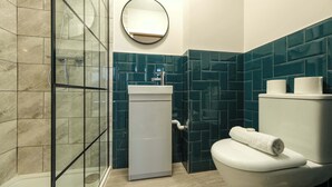 Une salle de bain avec une douche à parois de verre, un lavabo, des toilettes et un miroir.