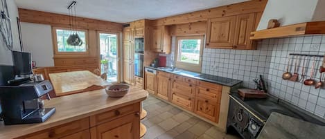A kitchen with wooden cabinets, a central island, a stove, and a window.