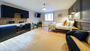 A compact living space with a kitchenette, a bed, a sofa, and a dining area. - The Willow - Studio 27 (Patchway)