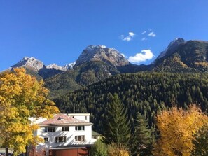 Un paisaje montañoso con un edificio blanco en primer plano.