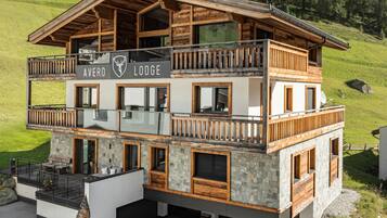 A two-story lodge with a wooden exterior, balconies, and a stone facade.