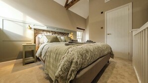 A bedroom with a bed, bedside table, and a window.
