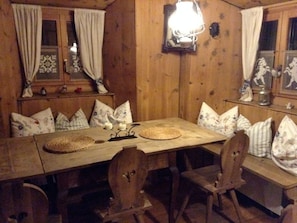 Ein Holztisch mit Stühlen, einer Kerze und einem dekorativen Gegenstand darauf.