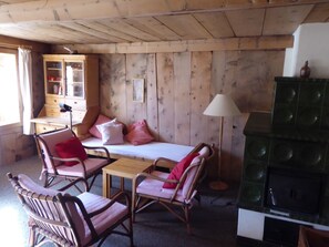 A cozy room with a bed, two chairs, a table, a cabinet, and a green cabinet. - Chasa Pitsch, (Tschierv) by Interhome (Tschierv)