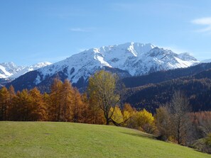 Un campo cubierto de hierba con una cadena montañosa al fondo.