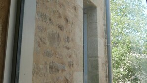A stone wall with a wooden ceiling and a window frame.