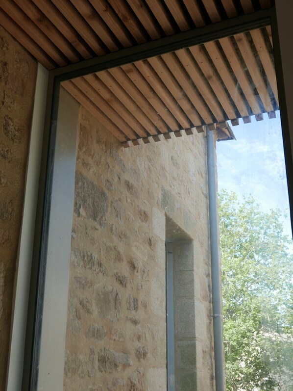Pared de piedra con techo de madera y un marco de ventana.