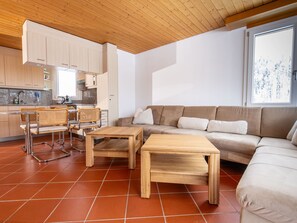 A modern living room with a sofa, two wooden tables, and wicker chairs. - Tschopp, (Samnaun-Compatsch) by Interhome (Samnaun)